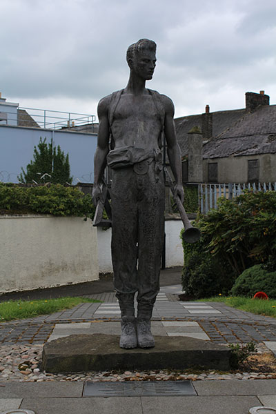 The bronze Alphabet Angel sculpture in Bushmills, depicting a figure holding two horns