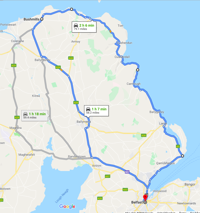 A Google Maps route comparison showing the direct A26 route and the scenic A2 Causeway Coastal Route from Belfast to Bushmills