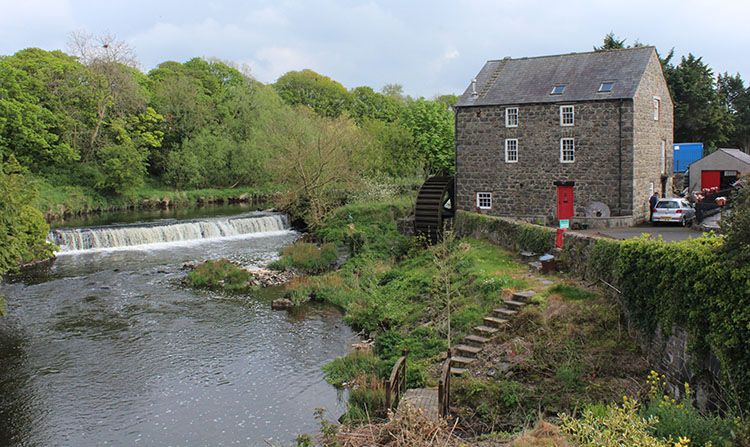 Curry’s Mill, a restored stone corn mill on the River Bush in Bushmills, seen across the weir