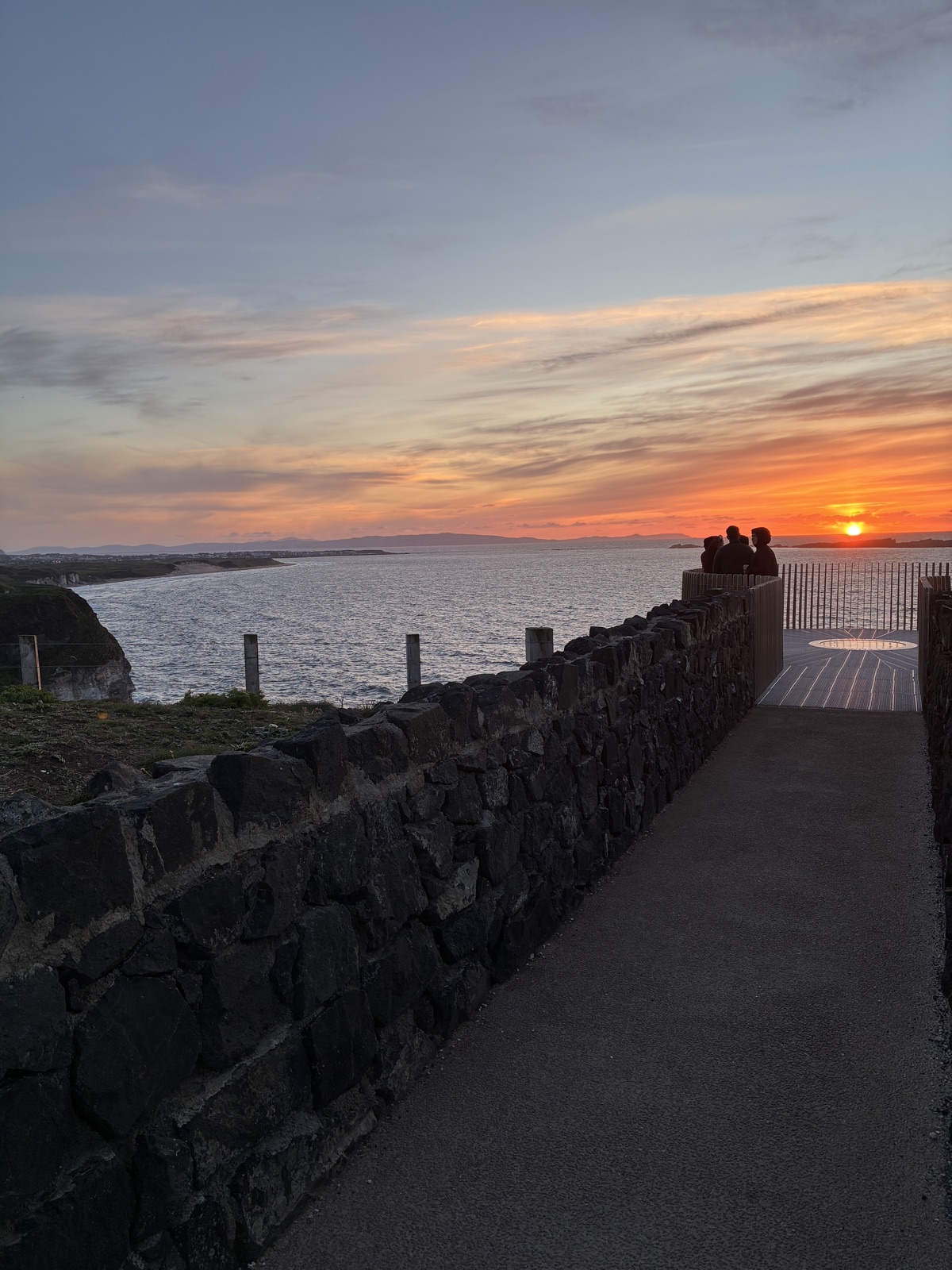 Visitors watching the sunset from Magheracross Viewpoint’s platform, overlooking the coastline and sea