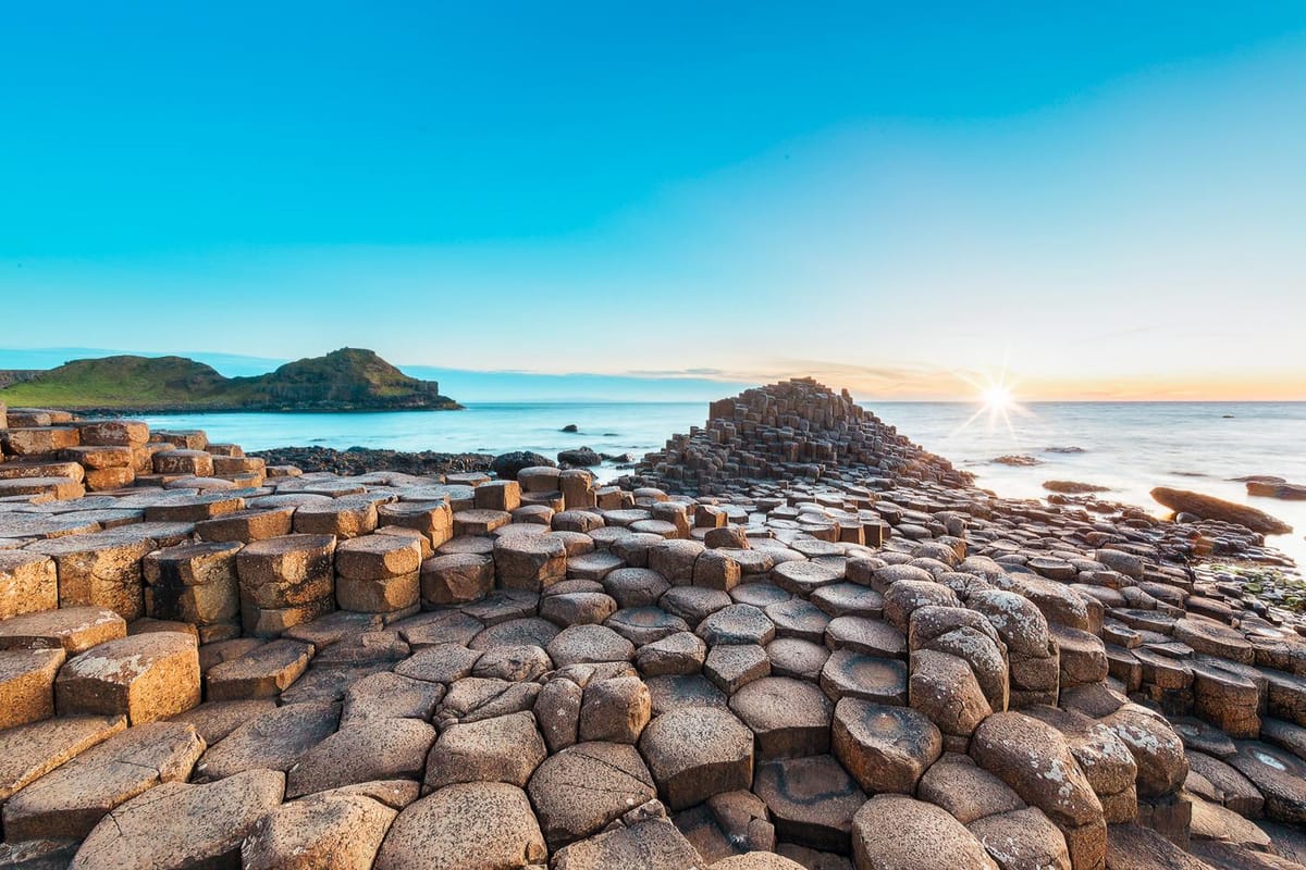 The Giant’s Causeway basalt columns at sunrise, with Rathlin Island visible in the distance