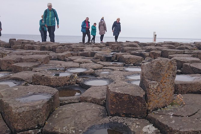 Visitors walking across the basalt columns of the Giant’s Causeway